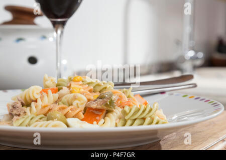 Bunte curly Makkaroni Salat mit Tomaten, surimi, Ei, Mais und Thunfisch Stockfoto