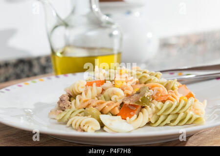 Bunte curly Makkaroni Salat mit Tomaten, surimi, Ei, Mais und Thunfisch Stockfoto