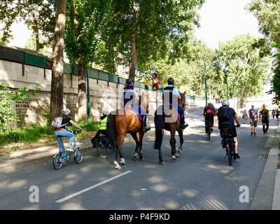 Kinder und Erwachsene Reiten Fahrräder letzten zwei gendarmen auf dem Pferderücken patrouillieren die richtige Bank Rives de Seine, während der Fête de la musique, Paris, Frankreich Stockfoto