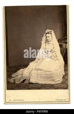 Der wunderschönen viktorianischen Braut, in für ein Portrait Foto in ihrer sehr langen Brautkleid und Schleier, von einem Fotografen in Torquay, England gebracht gestellt Stockfoto