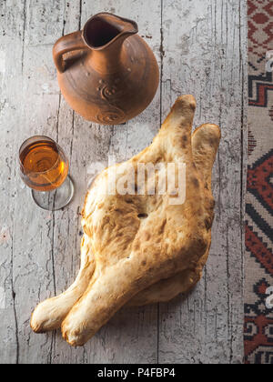 Blick von oben auf die leckere traditionelle georgische Fladen, Glas mit Getränke- und Ton Krug auf dem Tisch Stockfoto