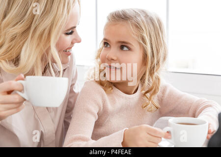 Mutter und Tochter sich einander, während Sie Kaffee im Cafe Stockfoto