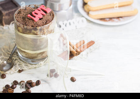 Hausgemachtes Tiramisu in Glas mit Schokolade, Kaffeebohnen und savoyardi Kekse. Copyspace Stockfoto