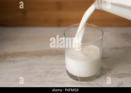 Abfüllung in Glas Milch aus der Flasche. Kopieren Sie Platz. Stockfoto