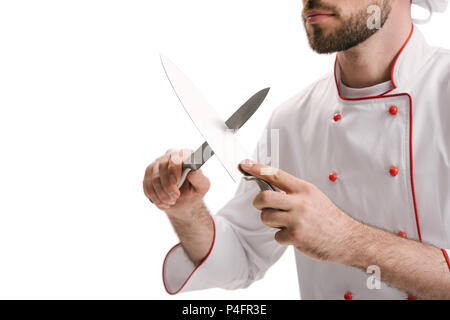 7/8 Schuß von jungen Koch Messer schleifen isoliert auf weißem Stockfoto