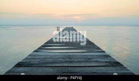 Dämmerung auf einem Holzsteg Stretching in den Stillen Ozean Stockfoto