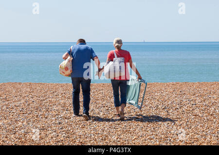 Hastings, East Sussex, UK. 22 Jun, 2018. UK Wetter: Schönes Wetter morgens in Hastings, East Sussex mit Höhen von 20 °C zu starten Abgebildet ist ein paar Hände halten, als Sie am Strand mit Liegestühlen. © Paul Lawrenson 2018, Foto: Paul Lawrenson/Alamy leben Nachrichten Stockfoto