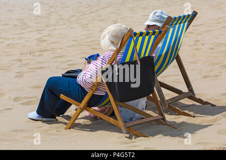 Bournemouth, Dorset, Großbritannien. Am 22. Juni 2018. UK Wetter: schön warmen sonnigen Tag in Bournemouth Strände als Besucher gehen zum Meer den Sonnenschein zu machen, wie die Prognose ist für Temperaturen weiter steigen. Paar in Liegestühlen am Strand. Credit: Carolyn Jenkins/Alamy leben Nachrichten Stockfoto