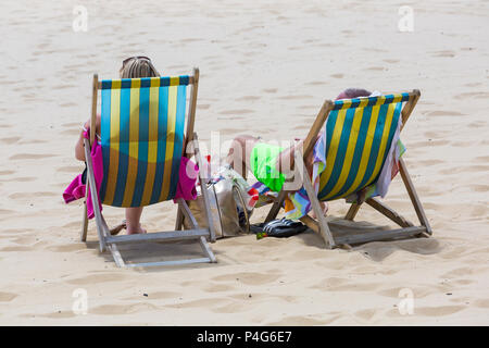 Bournemouth, Dorset, Großbritannien. Am 22. Juni 2018. UK Wetter: schön warmen sonnigen Tag in Bournemouth Strände als Besucher gehen zum Meer den Sonnenschein zu machen, wie die Prognose ist für Temperaturen weiter zu erhöhen. Paar in der Liegestühle am Strand - Blick nach hinten, Ansicht von hinten. Credit: Carolyn Jenkins/Alamy leben Nachrichten Stockfoto