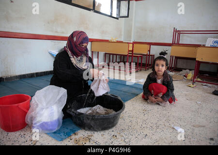 Sanaa, Jemen. 22. Juni, 2018. Eine vertriebene Jemenitischen Frau, die ihr Haus in den Krieg floh gebeutelten Hafenstadt Al Hudaydah wäscht Kleidung an einer Schule, wie die Auseinandersetzungen im westlichen Küste Bereiche vertiefen, in Sanaa, Jemen, 22. Juni 2018. Credit: Hani Al-Ansi/dpa/Alamy leben Nachrichten Stockfoto