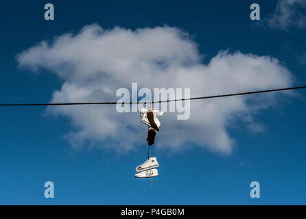 Berlin, Deutschland. 22. Juni, 2018. Schuhe und Schuh Modelle aus Karton hängen an einem Seil vor einer Wolke in Berlin Warschauer Straße. Credit: Paul Zinken/dpa/Alamy leben Nachrichten Stockfoto