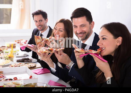 Nahaufnahme der Glückliche junge Geschäftsleute genießen Pizza Stockfoto