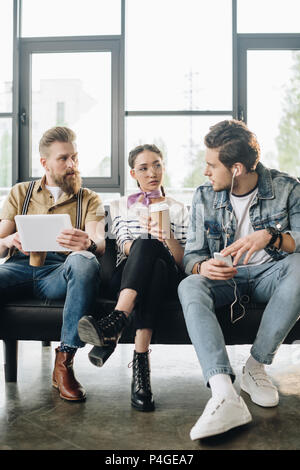 Diverse Business Team Ruhe und Verwendung digitaler Geräte in hellen Arbeitsbereich Stockfoto