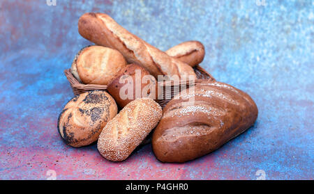 Brotkorb mit verschiedenen Brötchen. Gesalzene Roggen, Baguette, Zwiebel, Mohn, Sesam, und einfache Roll Stockfoto