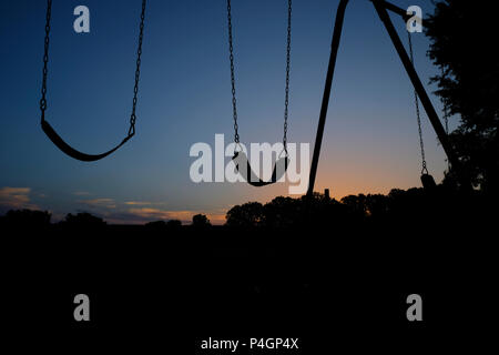 Silhouette der Leere schwingt der Spielplatz vor dem Sonnenaufgang vor den Kindern am See Benson Park in Garner Nord-carolina ankommen Stockfoto