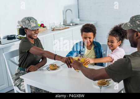 African American weibliche und männliche Soldaten und ihre Kinder Toasten mit Saft Stockfoto