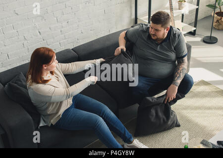 Freund und Freundin kämpfen mit Kissen zu Hause Stockfoto