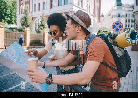 Multiethnischen Paar junge Touristen mit Karte und Kaffeetassen Stockfoto