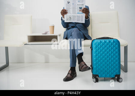 Zugeschnittenes Bild der Geschäftsmann im Wartezimmer sitzen und Zeitung lesen Stockfoto