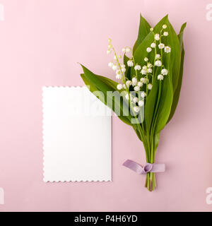 Strauß Blumen Lilie des Tales und leer mit roten Herzen auf Rosa pastell Hintergrund, schönes Frühstück, Vintage romantische Karte, Ansicht von oben, l Stockfoto