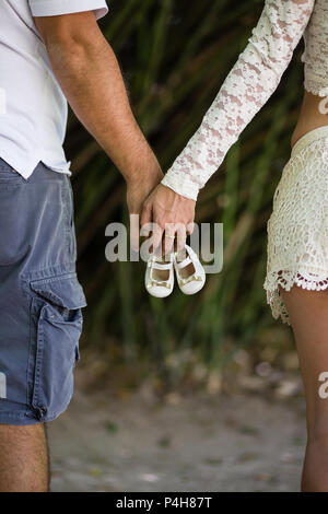 Detail der Eltern holding Golden Girl Schuhe, von hinten gesehen. Stockfoto