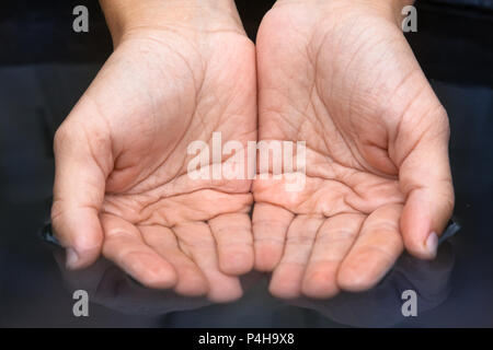 Hand Schaufeln sauber frisches Wasser aus einem Teich Stockfoto