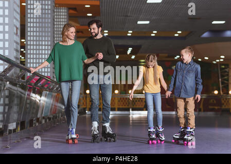 Eltern und Kinder Schlittschuhlaufen auf Roller Rink zusammen Stockfoto