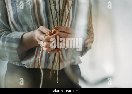 Blick auf weibliche Hände mit trockene Blumen am Arbeitsplatz 7/8 Stockfoto