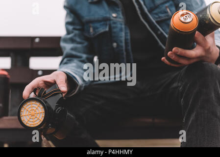 7/8-Ansicht der street artist Holding mit bunten Dosen Sprühfarbe Stockfoto