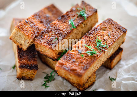 Appetitlich getoastetes Toast von Roggenbrot mit Dill auf weißem Hintergrund. Close-up Stockfoto