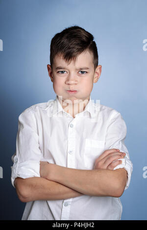 Closeup Portrait von wütenden jungen Junge, Nervenzusammenbruch, isolierte blauen Hintergrund. Negative menschliche Gefühle, Mimik, Gefühle der Reaktion auf Stockfoto