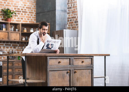 Stattliche Einzelgänger Geschäftsmann lesen Zeitung an Küche Stockfoto