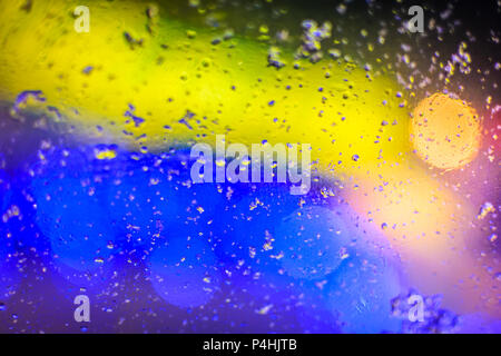 Mit den Farben gelb und blau Textur, unscharfe Tropfen Wasser und leichte Flecken auf dem Glas. Abstrakte Foto getönt Stockfoto