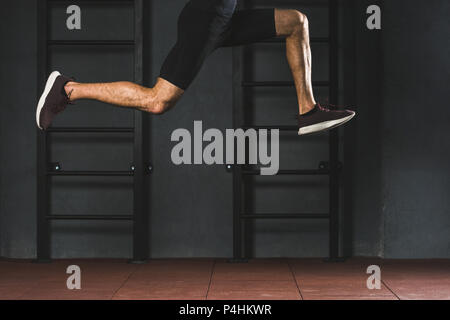 Zugeschnittenes Bild springen Sportler tun cardio übung in der Turnhalle Stockfoto