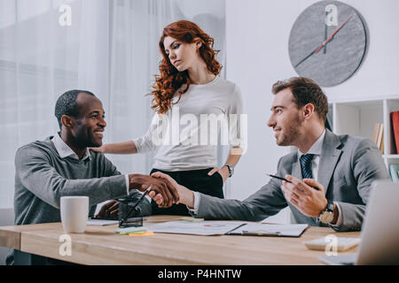 Interracial Paare im Büro eines Immobilienmaklers Stockfoto