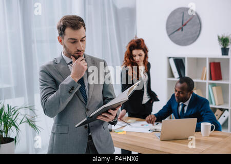 Multiethnischen Kollegen Schreibarbeit zu tun im Büro Stockfoto