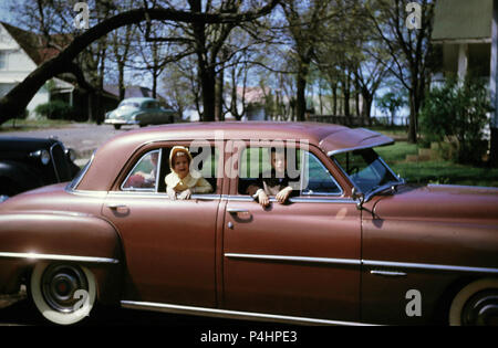 1950er Jahre, Kinder aus dem Fenster von einem Automobil in einem Heim Auffahrt, USA Stockfoto