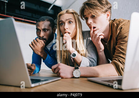 Erschrocken multikulturellen Kollegen beobachten auf Laptop Bildschirm Stockfoto