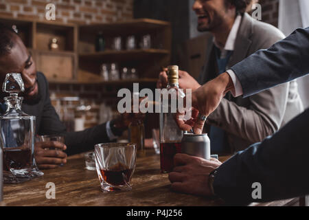 Zusammen 7/8 Schuß von Multiethnischen Männer in Anzügen trinken alkoholische Getränke Stockfoto