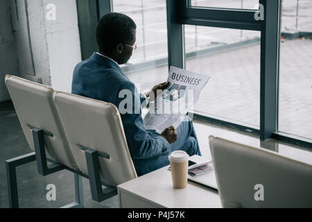 Afrikanische amerikanische Geschäftsmann, Zeitung lesen im Flughafen, während ein Abflug warten Stockfoto