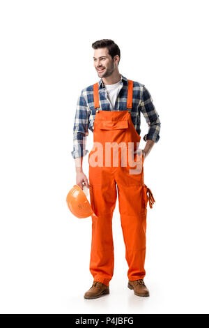 Junge Builder in Orange insgesamt Holding harten Hut isoliert auf weißem Stockfoto