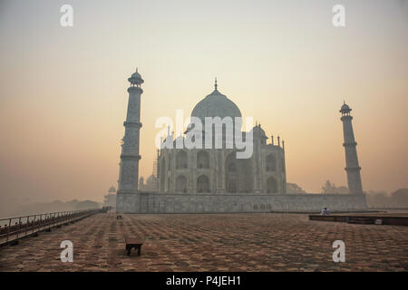 Agra, Indien. Weißer Marmor Taj Mahal Komplex mit Minaretten und Wänden durch den Dunst und Smog von Agra Fort Festung UNESCO Weltkulturerbe Stockfoto