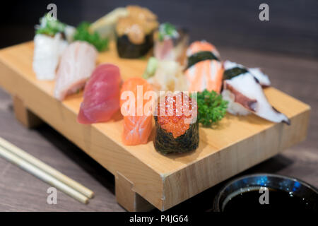 Close-up Sushi und Sashimi auf Holzplatte auf schwarzem Holz- Tabelle gemischt. Japanisches Essen. Stockfoto