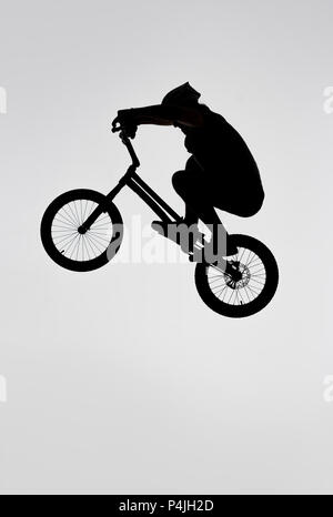 Silhouette des Versuches Radfahrer springen auf dem Fahrrad auf Weiß Stockfoto