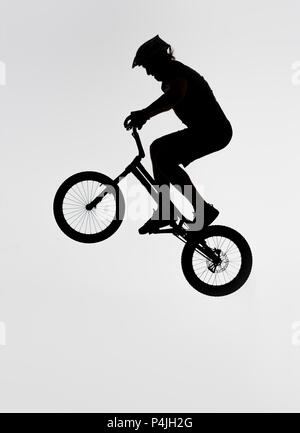 Silhouette des Versuches biker Springen auf dem Fahrrad auf Weiß Stockfoto