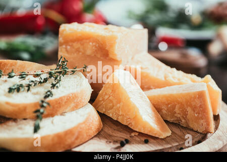 Nahaufnahme eines aufgeschnittenen Baguette und köstlichen Parmesan auf Holz Schneidebrett Stockfoto