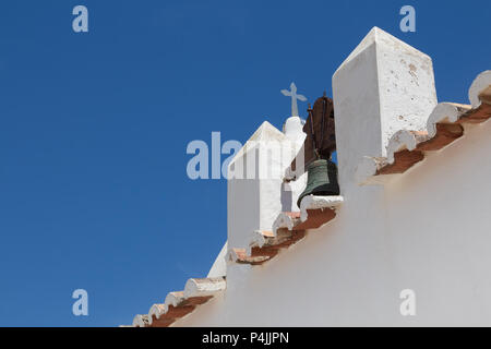 Diagonale Komposition von ein Detail einer weißen Kirche der Nossa Senhora da Rocha in Porches, Algarve, Portugal. Glockenturm, Rand von einem Dach und einem Kreuz. Hell Stockfoto