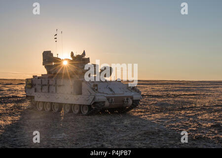 Die Sonne geht hinter einem Bradley fighting Fahrzeug als Bravo Company,1-163 rd kombinierte Waffen Bataillon, Montana Army National Guard in Erwartung für eine Nacht Iteration an der Orchard Training Center, Idaho, die am 19. Juni 2018 zu beginnen. (U.S. Armee Foto von SPC. Michael Hunnisett) Stockfoto