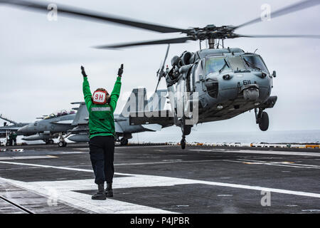 180620-N-MT 837-0078 PAZIFISCHER OZEAN (20. Juni 2018) Flieger Yulisa Hernandez Garcia leitet die Crew von einem MH-60S Sea Hawk Hubschrauber zum "Schwarzen Ritter" der Hubschrauber Meer Combat Squadron (HSC) 4 zugewiesen, wie es braucht, um von der Flight Deck der Nimitz-Klasse Flugzeugträger USS Carl Vinson (CVN 70). Carl Vinson ist derzeit in der Vorbereitung für die Teilnahme an den Rand der Pazifischen Übung 2018 im Gange. (U.S. Marine Foto von Mass Communication Specialist 3. Klasse Dylan M. Kinee/Freigegeben) Stockfoto