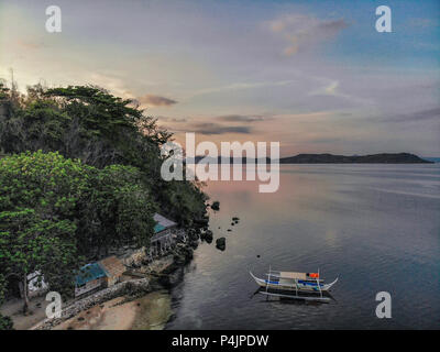 Arerial Ansicht einer philippinischen traditionelles Boot auch bekannt als bangka vor einem Strand resort angedockt Stockfoto